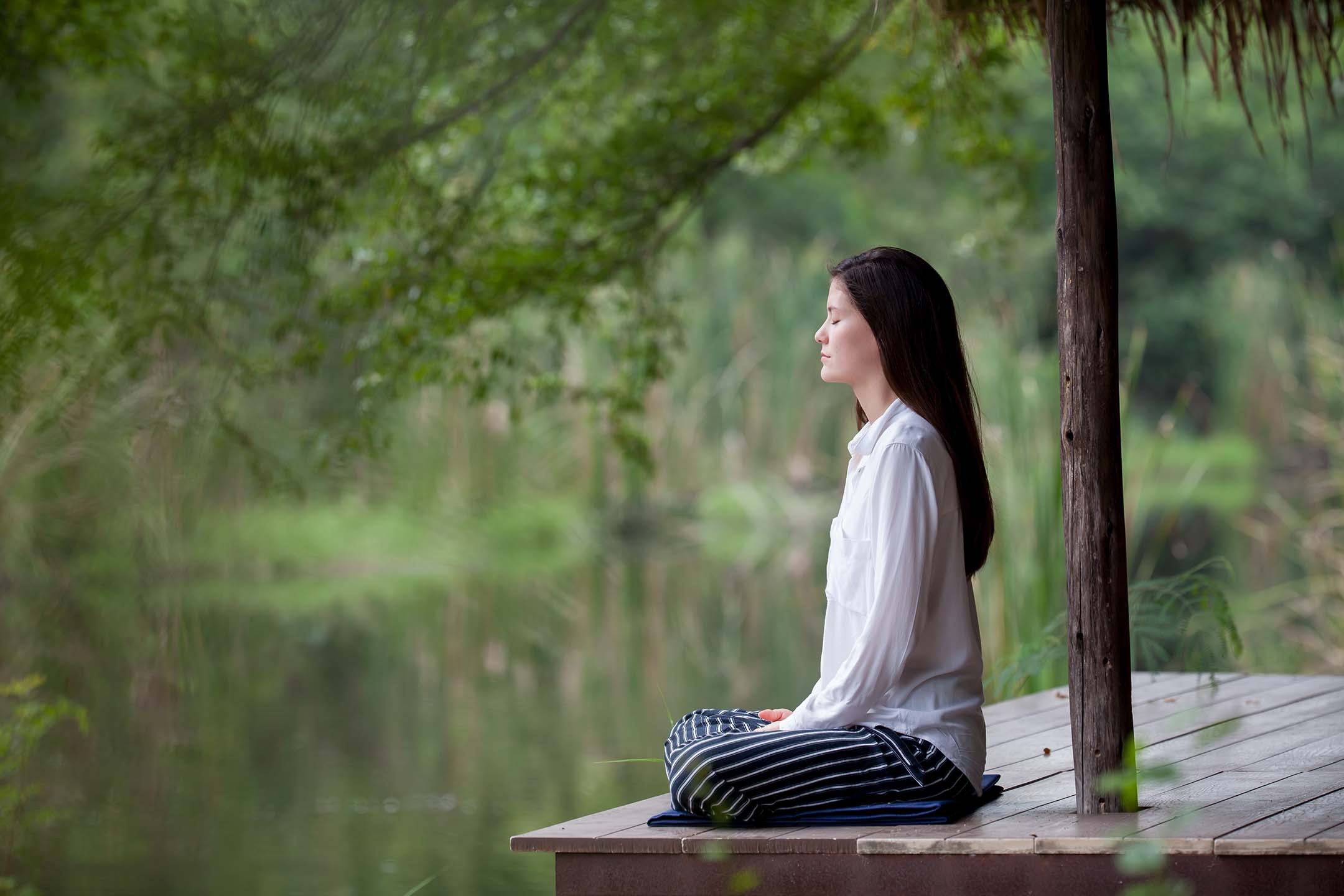 Woman Sitting by a Pond